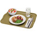 A Cambro rectangular olive green fiberglass cafeteria tray with food on it and a fork and knife.