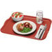 A red Cambro rectangular tray with food and a fork on it.