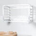 A Channel metal sheet pan rack holding baking pans on a wall.