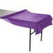 A Creative Converting amethyst purple plastic table cover on a table.