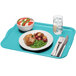 A Cambro robin egg blue rectangular fiberglass tray with food on it and a fork and knife on a napkin.