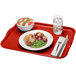 A red Cambro rectangular tray with food and a fork on it.
