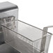 A stainless steel basket with a wire handle in a Dean electric floor fryer.