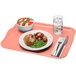A Cambro rectangular blush fiberglass tray with food, a fork, and a knife on a napkin.
