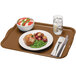 A brown Cambro rectangular tray with food on it and a fork.