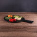 An Elite Global Solutions faux slate serving board with vegetables on it on a table.