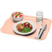 A light peach Cambro rectangular fiberglass tray with food including potatoes, meat, and a bowl of mozzarella cheese, tomatoes, and basil.
