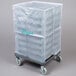 A Noble Products translucent vinyl glass rack dust cover in a plastic bag on a cart.