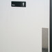 A black rectangular sign with white text reading "Men" on a metal door.