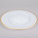 A white Charge It by Jay alabaster glass charger plate with a gold rim.