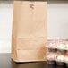 A Duro brown paper bag with a white handle filled with cupcakes.