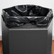 A black Commercial Zone PolyTec outdoor waste container with an open top and a black bag inside.
