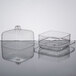 A clear plastic container with a clear lid containing Fineline clear square trays with lids.