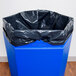 A blue hexagonal waste container with black plastic lid.