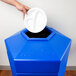 A hand putting a white plate into a blue Commercial Zone PolyTec waste container.