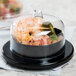 A Fineline black round tray with a clear lid on top containing shrimp and vegetables.