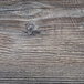 A close up of a wood surface with scratches and cracks.