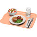 A dark peach Cambro fiberglass tray with a plate of food and a fork on it.
