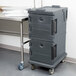 A Cambro Ultra Camcart food pan carrier in granite gray with a black door.