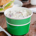 A green and white Choice paper food cup filled with food.