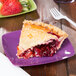 A slice of pie on a purple Fineline Renaissance square dessert plate next to a plate of fruit.