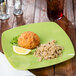 A Fineline green square plastic plate with a crab cake and rice on it.