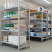 A Cambro Camshelving Premium mobile unit with bottles and containers on the shelves.