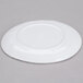 A white Urban Mill round coupe plate with an irregular shape on a gray surface.