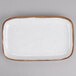 A white rectangular platter with brown speckled edges.
