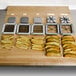 A cutting board with a Choice Prep 1/2" French Fry Cutter and different types of french fries.