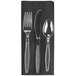 A black linen-feel napkin with clear heavy weight plastic silverware on top.