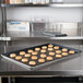 A Vollrath Wear-Ever bun sheet pan of cookies on a counter.