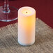 A white Sterno flameless wax candle on a table.