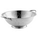 A close-up of a stainless steel Vollrath colander with a base and handles.