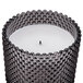 A Sterno gray wax filled glass lamp with a hobnail design containing a flameless candle.
