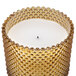 A Sterno amber flameless wax filled glass lamp with a beaded design on it.