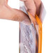 A hand holding a Menu Solutions Hamilton Mandarin menu board in a plastic bag.