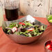 An American Metalcraft satin stainless steel bowl filled with strawberries on a table.