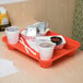An orange GET Fast Food Tray with food and drinks on it.