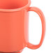 A close-up of a GET Rio orange plastic mug with a handle.