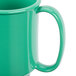 A close up of a rainforest green Tritan mug with a handle.