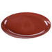 A red oval melamine platter with a speckled surface and brown rim.