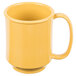A close up of a yellow mug with a handle.