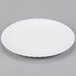 An American Metalcraft white melamine plate with a rippled edge on a gray surface.