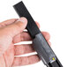 A hand holding a black and grey Unger Ninja Squeegee Endclip