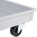 A gray fiberglass dolly with wheels and a black handle for MFG Tray pizza dough boxes.