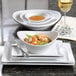 A Libbey Infinity bright white porcelain bowl filled with shrimp noodles on a plate.