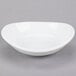 A Libbey Infinity bright white porcelain bowl with a small rim on a gray surface.
