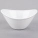 A close-up of a Libbey Infinity white porcelain bowl with a curved edge on a gray surface.