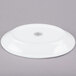 A bright white oval porcelain platter with a rolled edge and a circular design on it.